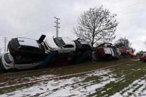 Devět nových aut na přívěsu skončilo v příkopu a tahač na boku