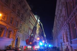 Střecha pražského činžáku v ohni, obyvatelé domu na ulici