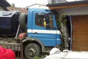 Nákladní auto po střetu s osobním vozem prorazilo plot a nabouralo do garáže