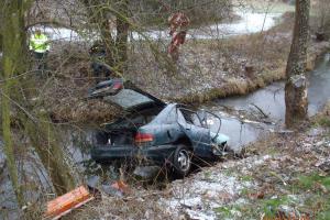 Osobní automobil skončil po dopravní nehodě na střeše v potoce