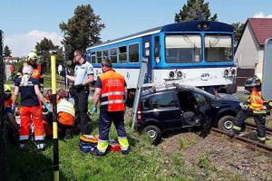 Srážka vlaku s osobákem. Řidič samozřejmě skončil v sanitce