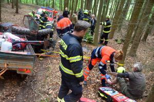 V kabině převráceného traktoru zůstal na lesní cestě zaklíněný řidič