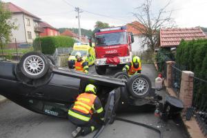 Jako by plot nestačil. Řidič při havárii ještě převrátil auto na střechu