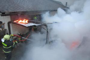 Požár se z vozidla rozšířil na uskladněné dřevo i garážová vrata